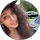 Woman wearing a hat, curly hair, outdoors.